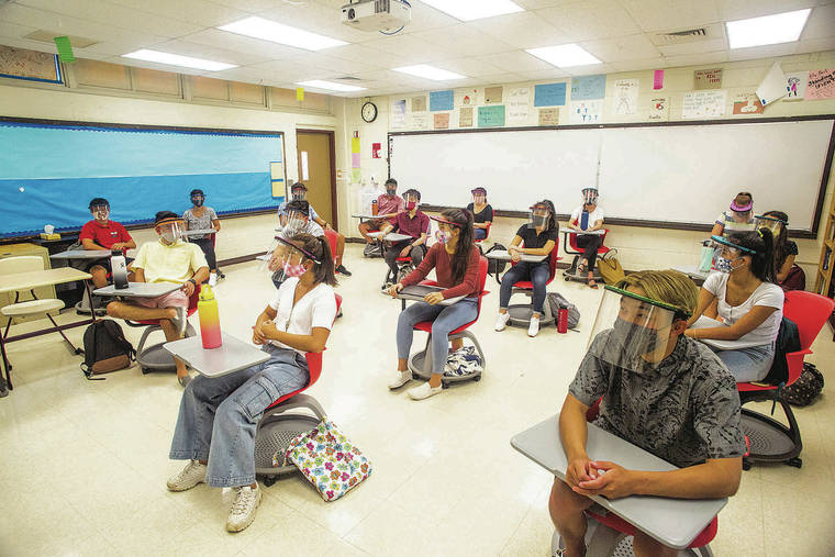 A group of people sitting in chairs and using laptops.