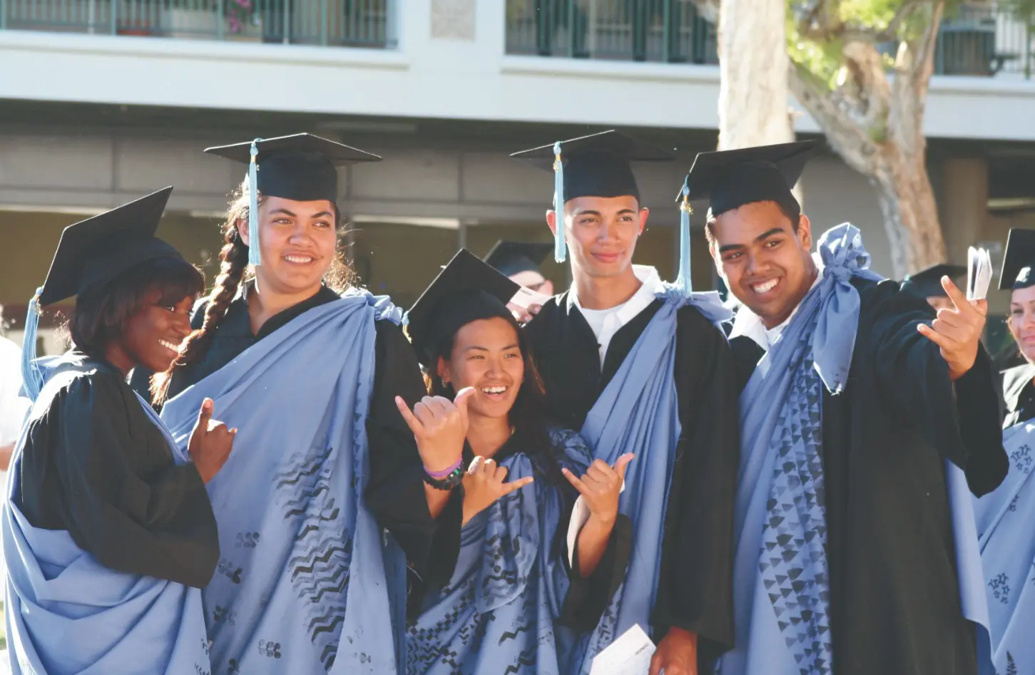 A group of people in graduation attire pose for the camera.