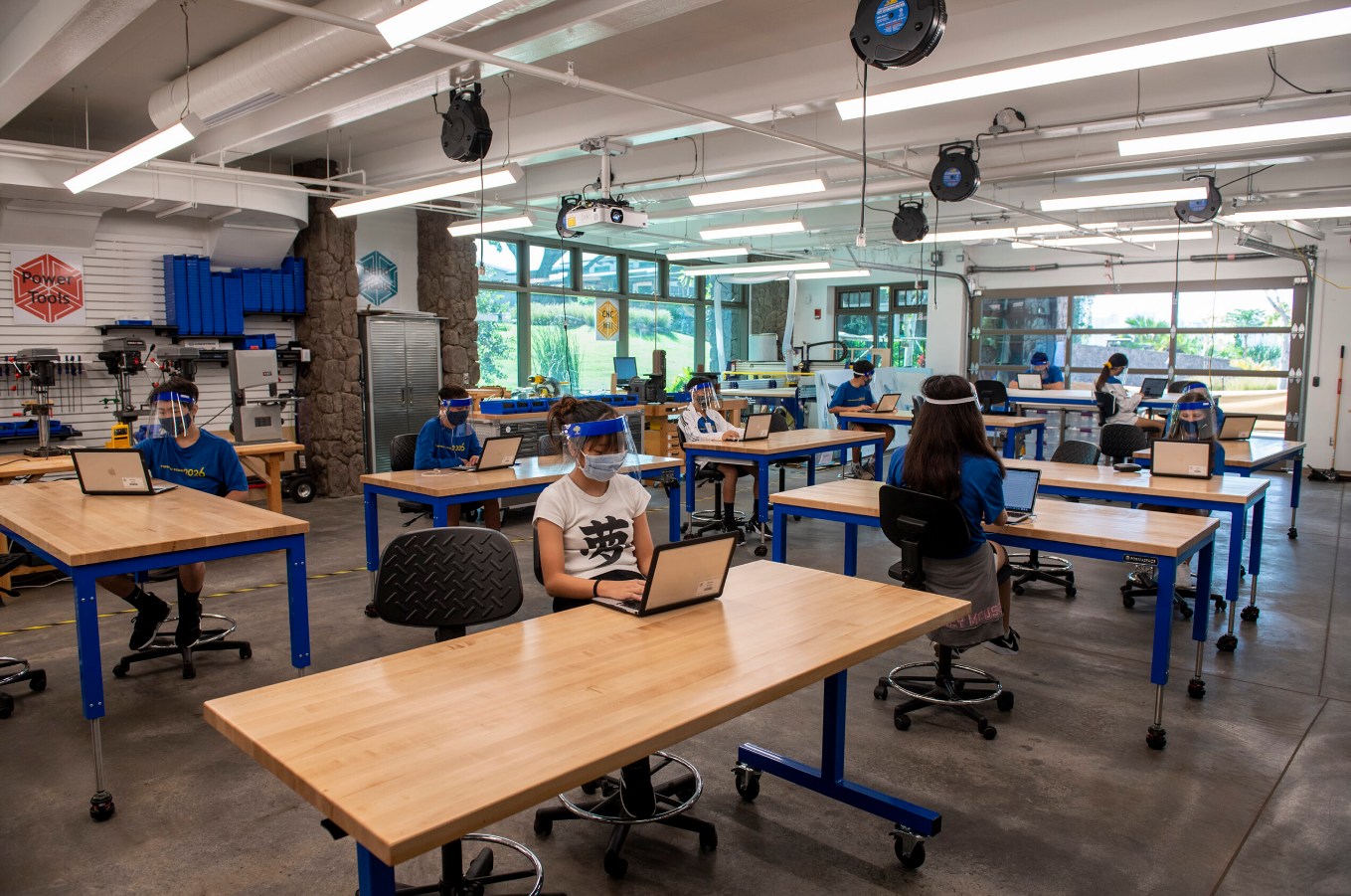 A group of people sitting at tables in an office.