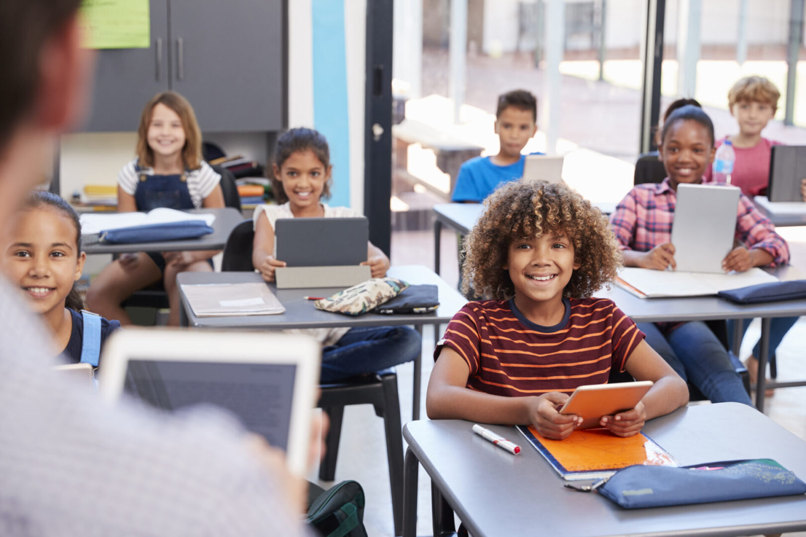 Elementary students looking at teacher, over shoulder view
